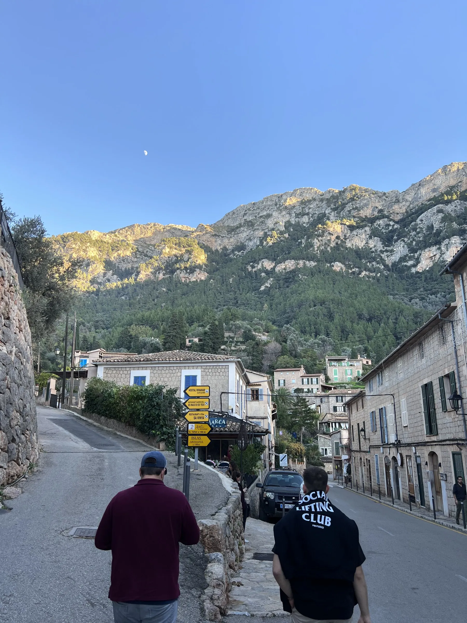 La calle principal de Deià una tarde de invierno, con las casas de piedra y la sierra iluminada por el último sol.